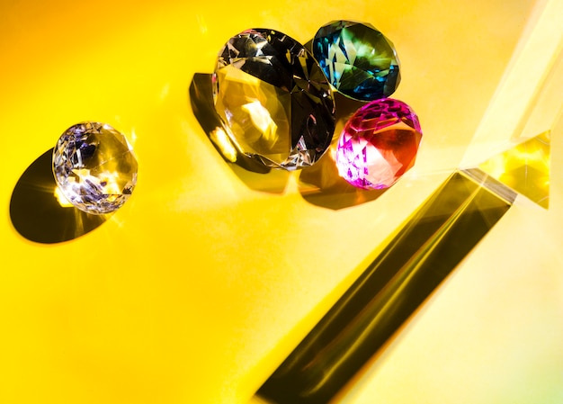 Diferentes tipos de diamantes sobre fondo amarillo.
