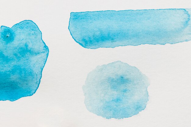 Diferentes tipos de manchas de acuarela azul sobre fondo blanco