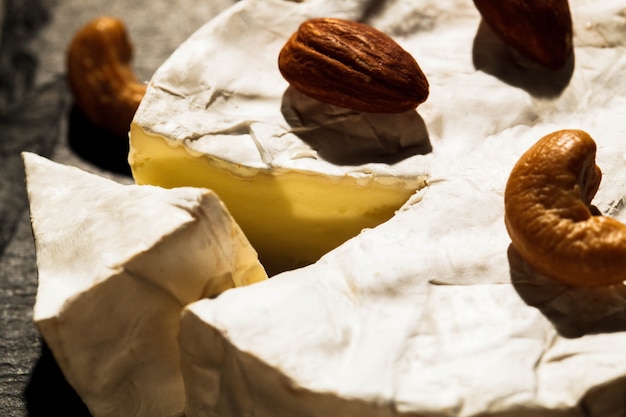 Diferentes tipos de nueces se encuentran en queso brie en plato negro