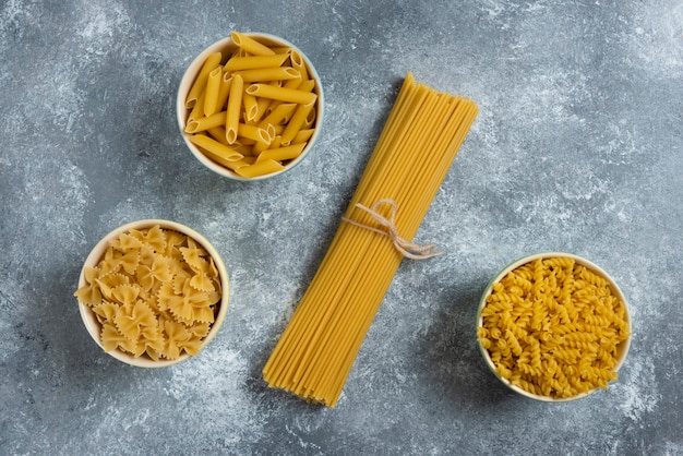 Foto gratuita diferentes tipos de pasta en gris.