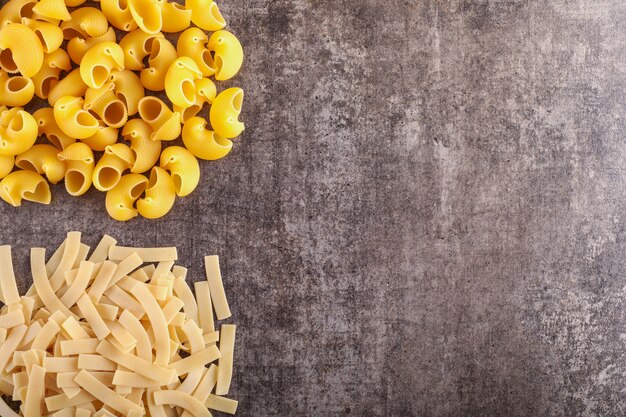 diferentes tipos de pasta a la izquierda con espacio de copia en la superficie de piedra gris