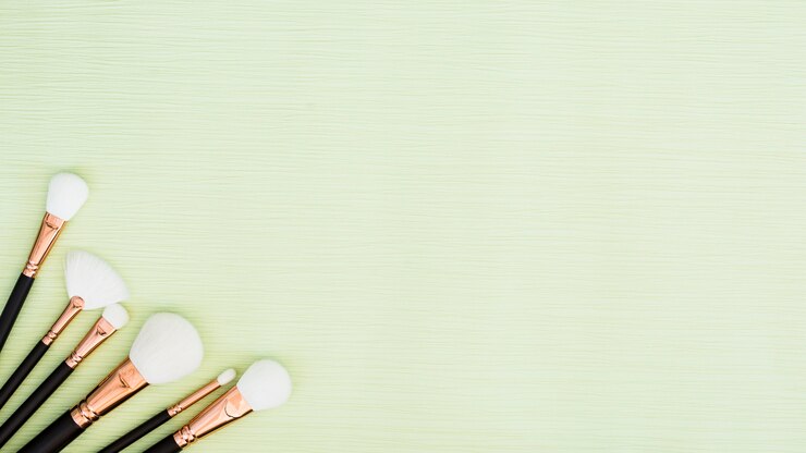 Foto gratuito diferentes tipos de pinceles de maquillaje blanco en la esquina del fondo de menta verde