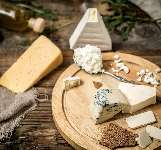 Diferentes tipos de queso sobre fondo de madera, composición, delicatessen, concepto y quesos gourmet