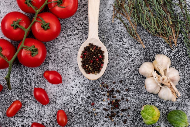 Foto gratuita diferentes tipos de vegetales con pimienta en la cuchara de madera sobre fondo de piedra