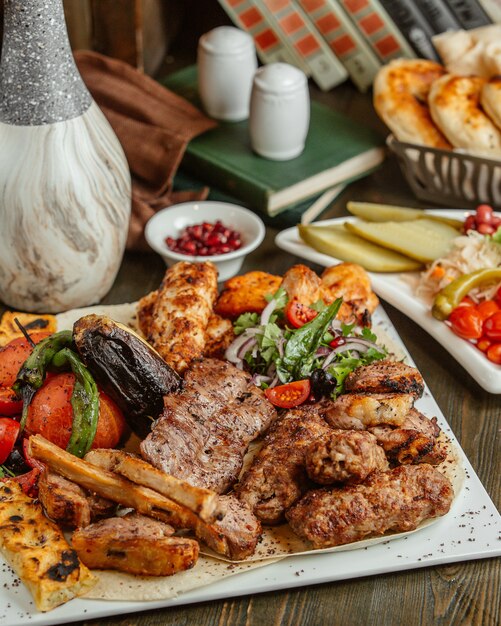 Diferentes variedades de kabab servidas con berenjenas a la parrilla y tomates