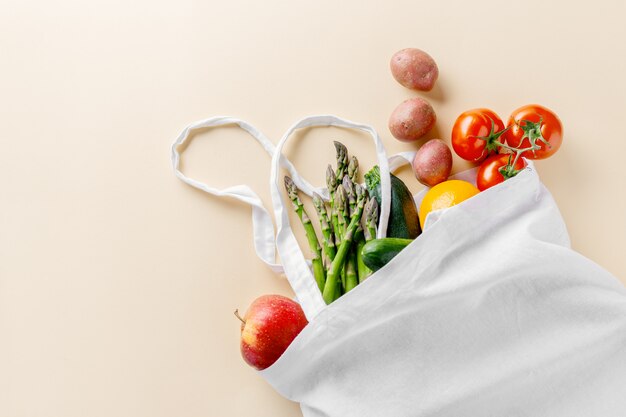 Diferentes vegetales en bolsa textil en color beige.