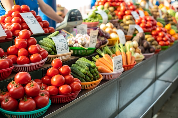 Diferentes verduras frescas en cestas en el mostrador.