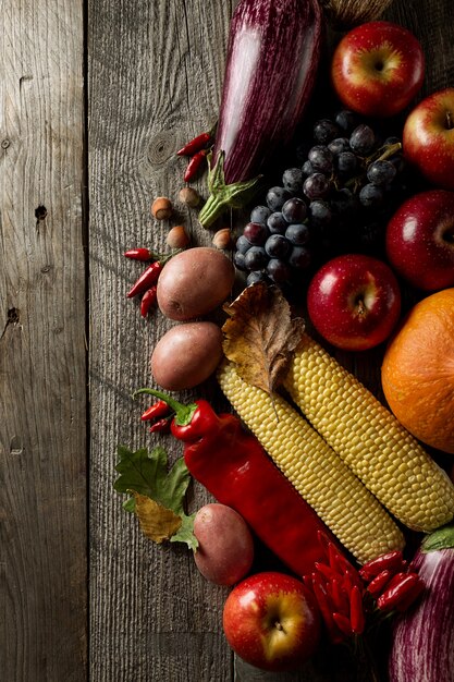 Diferentes verduras de otoño de temporada y frutas sobre fondo de madera