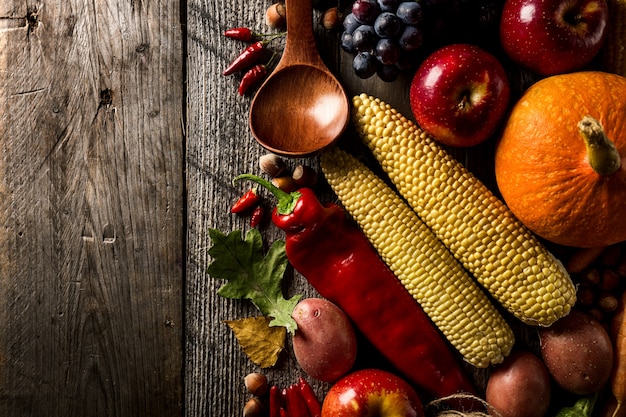 Diferentes verduras de otoño de temporada y frutas sobre fondo de madera