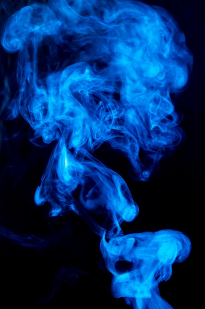 Difunde humo denso de remolino azul sobre fondo negro