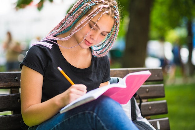 Foto gratuita diligente estudiante trabajando en la tarea