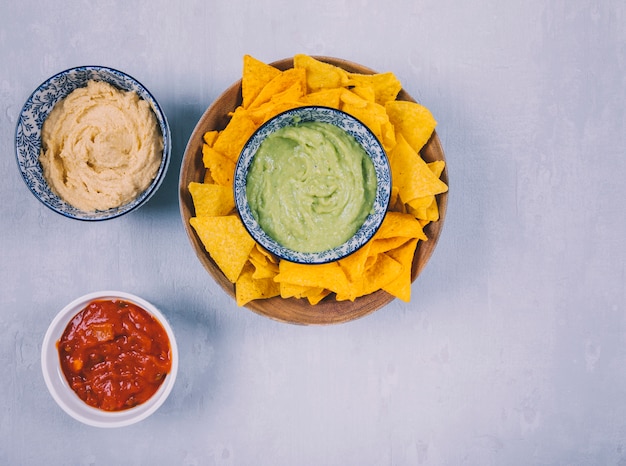 Dip de guacamole mexicano y chips de tortilla de nachos con salsa en tazones