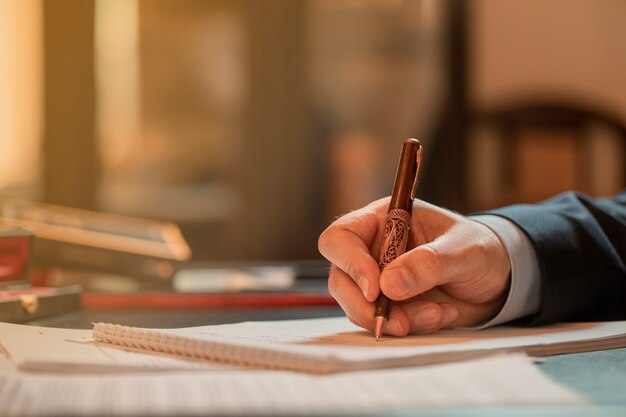 Director firmando documentos con un bolígrafo de moda. Foto de alta calidad