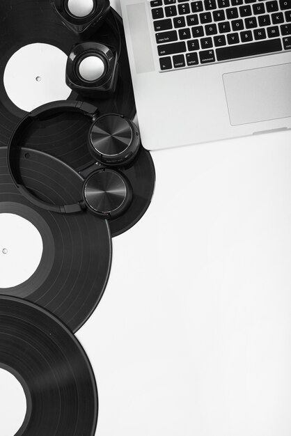 Discos de vinilo; Auricular y altavoz inalámbrico con laptop contra fondo blanco