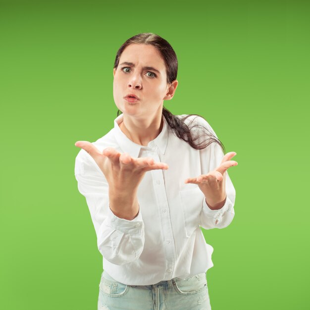 Discutir, argumentar concepto. Hermoso retrato femenino de medio cuerpo aislado sobre fondo verde de estudio.