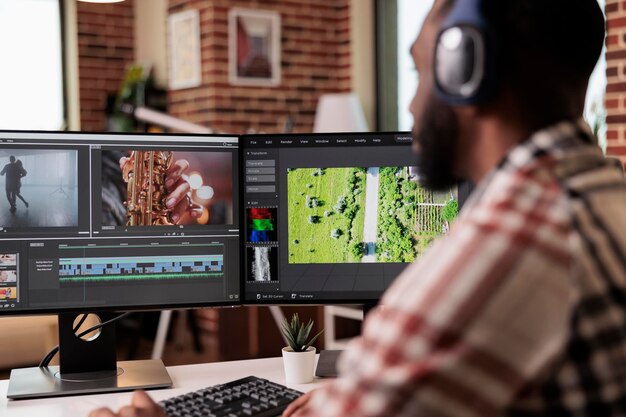 Diseñador gráfico editando metraje en software, trabajando para editar montajes de video con gradación de color y efectos de audio. Contenido de producción de sonido y cine, haciendo películas creativas en la computadora.