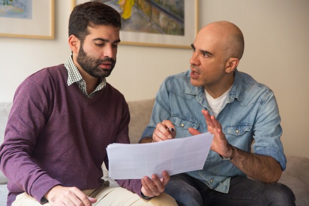 Diseñador de interiores y dueño de casa discutiendo sobre bocetos