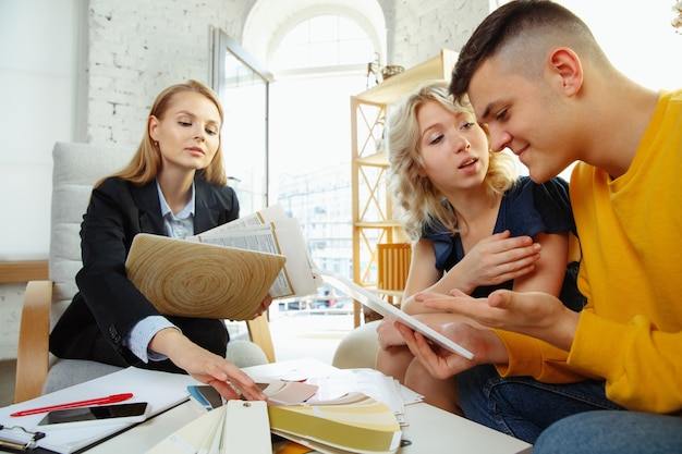 Diseñador de interiores trabajando con pareja joven.