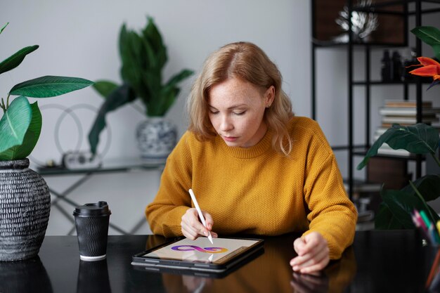 Diseñador de logo femenino trabajando en una tableta gráfica