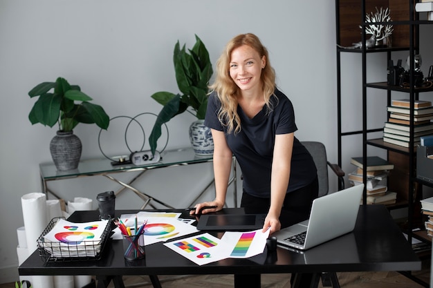 Diseñador de logotipo femenino trabajando en su oficina en una tableta gráfica