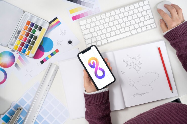 Foto gratuito diseñador de logotipos sosteniendo un teléfono inteligente con un logotipo genial