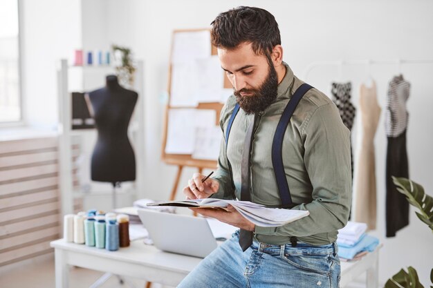 Diseñador de moda masculino guapo en atelier