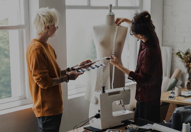 Diseñador de moda usando una cinta métrica en un maniquí