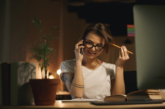 Diseñador de mujer concentrada hablando por teléfono móvil