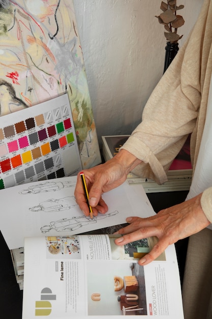 Diseñadora de moda femenina en el estudio trabajando en ropa