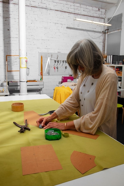 Foto gratuita diseñadora de moda femenina en el estudio trabajando en ropa