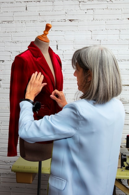 Diseñadora de moda femenina en el estudio trabajando en ropa