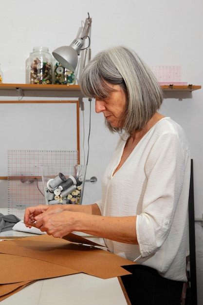 Diseñadora de moda femenina en el estudio trabajando en ropa