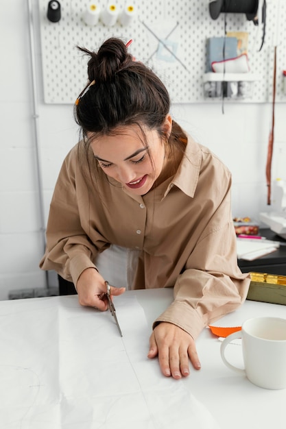 Foto gratuita diseñadora de moda trabajando sola en su taller