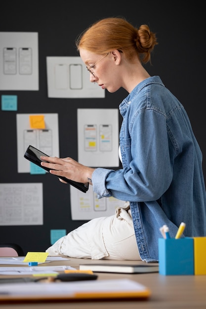 Diseñadora web femenina en la oficina con dispositivo de tableta