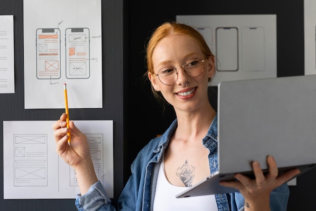 Foto gratuita diseñadora web femenina en la oficina con laptop