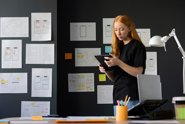 Foto gratuita diseñadora web femenina en la oficina con notebook