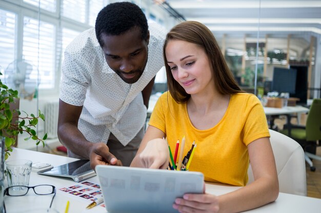 diseñadores gráficos masculinos y femeninos que discuten sobre la tableta digital