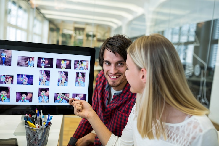 Foto gratuito diseñadores gráficos masculinos y femeninos que interactúan sobre la computadora