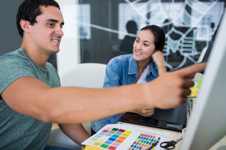 Foto gratuito diseñadores gráficos masculinos y femeninos que interactúan sobre la computadora