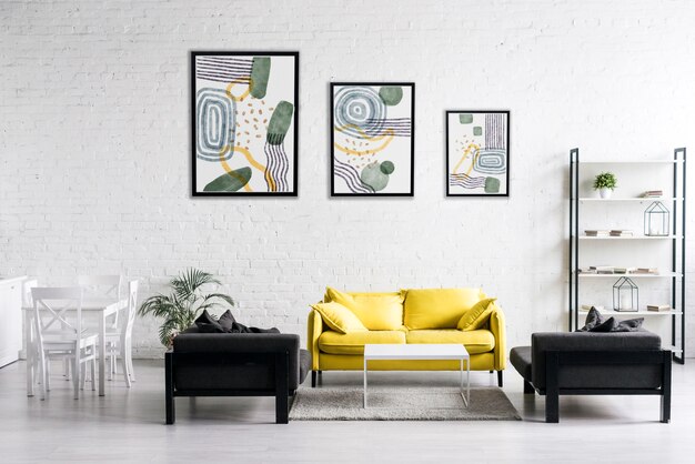 Diseño de interiores con marcos de fotos y sofá amarillo.