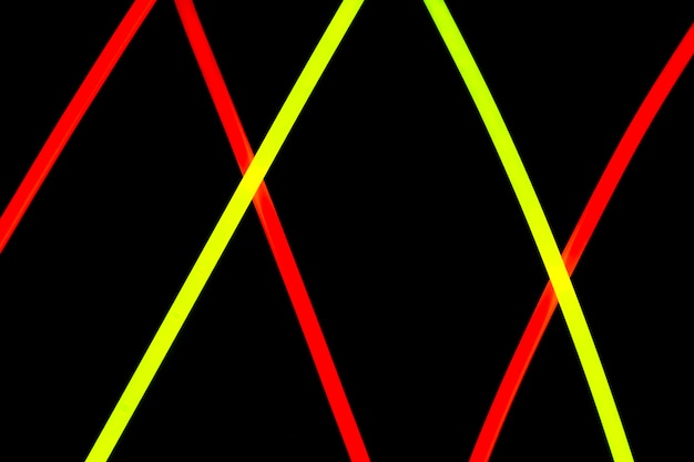 Diseño de líneas de neón rojo y amarillo diagonal sobre fondo negro