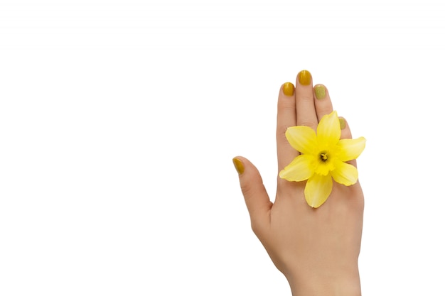Diseño de uñas amarillas. Mano femenina con manicura glitter sobre fondo blanco.