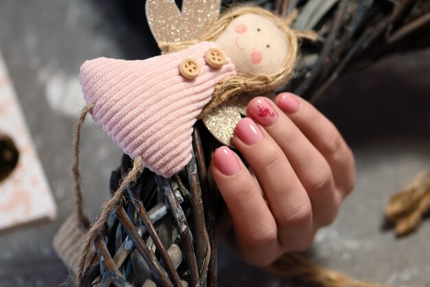 Diseño de uñas rosadas. Mano femenina con manicura rosa.