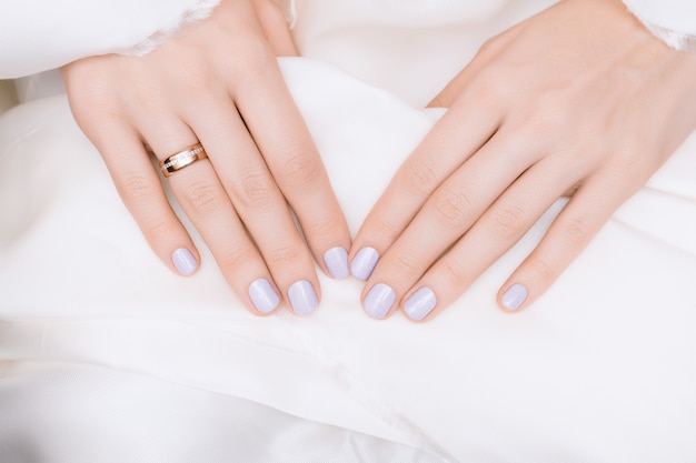 Diseño de uñas rosadas. Manos femeninas con brillo manicura.