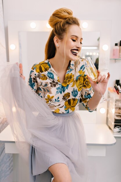 Disfrutando de momentos felices en la peluquería del modelo de moda con una copa de champán