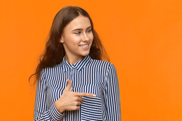 Disparo aislado de alegre chica de moda con camisa a rayas sonriendo ampliamente