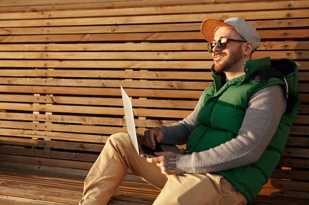 Disparo al aire libre de hombre caucásico joven con estilo guapo vistiendo snapback