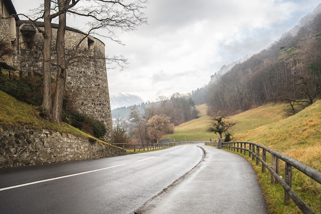 Disparo de alto ángulo de una carretera bajando una colina junto al castillo de Vaduz en Liechtenstein