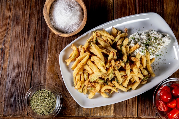 Disparo de alto ángulo de unas deliciosas patatas fritas en una placa blanca.