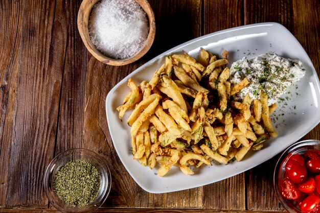 Disparo de alto ángulo de unas deliciosas patatas fritas en una placa blanca.